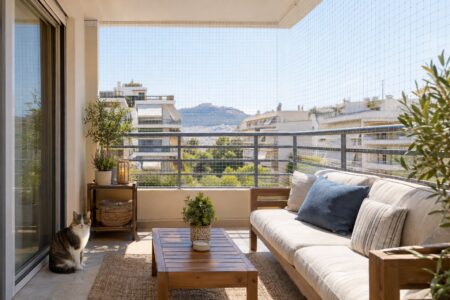 Γάτα σε ασφαλές μπαλκόνι ενοικιαζόμενου σπιτιού με διακριτικό προστατευτικό δίχτυ